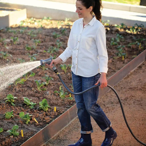 Woman using Heavy Duty Garden Hose 5/8 Inch By 75 Feet, Flexogen Strength, 8 Ply Double Tire Cord Reinforced in a garden
