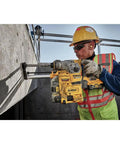 Worker using Heavy Duty Cordless 20V Brushless Rotary Hammer Drill Sick Power Bad Boy on concrete wall.