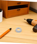 No Fuss 3/4 Inch Plastic Insulating Bushings 100 Pack on a wooden desk with a pen and drill.