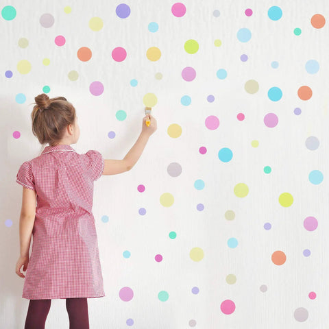 Girl applying 288 Pieces Polka Dot Wall Stickers Set Large Round Confetti Dots Peel And Stick Decor for Bedroom on wall.