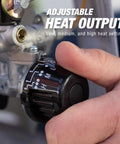 Close-up of hand adjusting heat setting on 15,000 BTU Single Tank Top Portable Propane Radiant Heater With Adjustable 15,000 12,500 And 10,000 BTU Levels, Quiet Instant Radiant Heat, Tip-Over Safety Switch, Up To 29 Hour Run Time On A 20 lb Tank, Outdoor Use Only.