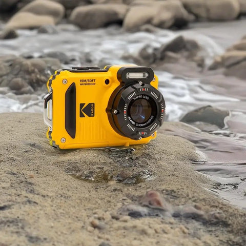 Rugged Waterproof Digital Camera With 50 Feet Depth Rating, 16MP Sensor, 4X Optical Zoom, placed on rocks by water
