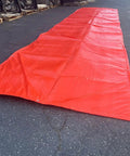 Dang Tough Insulated Concrete Blanket 6X25 Ft laid out flat on asphalt, showcasing heavy-duty grommets and vibrant color.