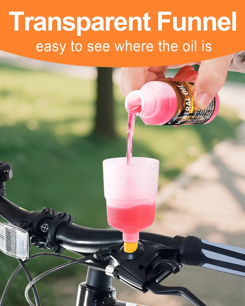 Pouring fluid into the clear funnel of the Road Ready All In One Brake Bleed Kit for Hydraulic Disc Brakes on a bike handlebar.