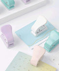 Assorted colored quarter-inch single hole punchers on a desk, featuring 6mm round holes and 10 sheets capacity for DIY projects