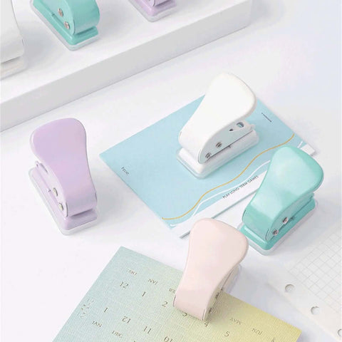 Assorted colored quarter-inch single hole punchers on a desk, featuring 6mm round holes and 10 sheets capacity for DIY projects