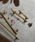 Hella Cool Vintage Antique Brass Cabinet Knobs With Classic Striped Groove and pulls on a table with decor.