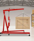 Heavy Duty Two Ton Hydraulic Engine Hoist Crane With Telescopic Boom Foldable Design lifting a wooden crate in a garage.