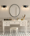 2 Light Vanity Light Fixture With Clear Glass Shades And Matte Black Finish over mirror in elegant bathroom setting