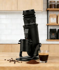 Heavy Duty Electric Burr Coffee Grinder With Sixty Fine Adjustments And 48 Millimeter Conical Steel Burrs For Dank Fresh Grinding And Smooth Barista Style Single Dose Pulls on a kitchen counter.