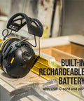 WorkTunes Connect Wireless Hearing Protector With Bluetooth Technology 26 DB Noise Reduction Rating Dope Sound Quality and Safe Volume Control for on-the-job use, shown on a workbench with built-in rechargeable battery.
