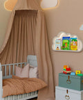 Nursery with canopy over crib, cloud-shaped shelf holding children's books, and toy chests beneath.