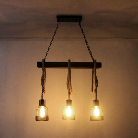 Farmhouse Pendant Light For Kitchen Island With Black Metal And Wood Beam Finish, Rustic Dining Room Ceiling Fixture, Three E26 Sockets Pendant Light, Built Tough, Easy Install Lighting For Country And Modern Homes with glowing bulbs in dark setting.
