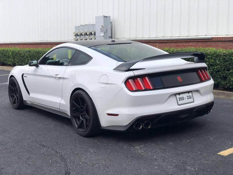 Rear view of a white sports car with Dope Black Chrome Finish License Plate Frame Set, Stainless Steel Construction With Screw Caps.