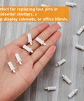 No Grunt Work Needed Spring Loaded Shutter Repair Pins For Plantation Blinds 30 Piece Replacement Kit in a hand on wooden surface.