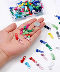 Hand holding colorful metal zipper sliders from 100 Pcs Metal Zipper Slider Replacement Kit Size 3 Universal Zipper Repair 12 Color Options