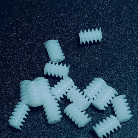 Close-up of 10 Pack 0.3 Module Plastic Mini Worm Gears Kit, 0.65mm Inner Hole, 3.5 By 5mm Size on black surface.