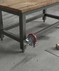 Heavy Duty Polyurethane Plate Casters With Brakes For Industrial Carts And Equipment Replacement attached to workbench on concrete floor