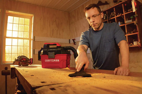 Man using Cordless Shop Vac Vacuum Cleaner Wet And Dry 2 Gallon Tank With 7 Foot Hose Bare Tool Only in home workshop