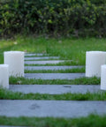 Four XL Flameless Pillar Candles with Remote on outdoor path, weatherproof LED, 6.45 by 8 inches, flickering warm light, waterproof resin build