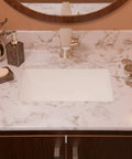 Rectangular Undermount White Porcelain Sink With Matte Black Drain Set And Overflow Pop Up Drain Sealer Included For Easy Install 1.75 Inch Drain Opening Inside Dimensions 11.5 By 16.25 By 6.5 Inches on marble countertop
