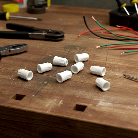 Front view of white high-temp ceramic wire nuts (30 pcs) scattered on a wooden workbench with loose wires.