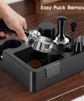 Kickass 58mm Espresso Accessories Kit With Integrated Tamping Station showcasing a hand holding the portafilter above the station.