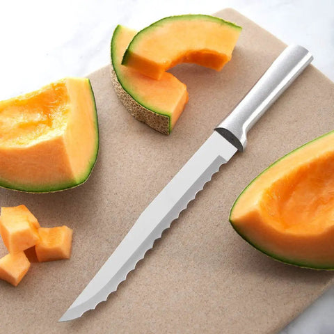 Smooth Serrated Slicer Knife With Knockout Double Sided Teeth That Crush Through Tough Produce Skins Like Hot Knife next to cantaloupe slices on a cutting board.