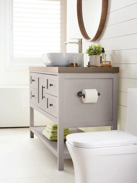 Bathroom scene with Matte Black Single Post Toilet Paper Holder Seven And A Quarter Inch Arrondi Bath Tissue Holder on gray vanity.