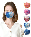Woman wearing patterned KN95 face mask with four colorful masks beside, 5-ply breathable safety cup style with snug 3D nose clip.