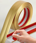 Top Tier Matte Gold L Shaped Corner Guards Peel And Stick Molding Trim For Furniture Edge Bumper Table Door Frame Protector No Sweat Diy Installation Smooth Vibe Check For Any Crib Upgraded Room Makeover At Sixteen Feet Long roll depicting the self-adhesive feature.