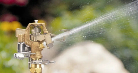 Two Pack Half Inch BRS Sprinkler Head Connection Fitting Tailored For Impact Heads With Anti Backsplash Valve spraying water in garden.