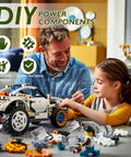 Father and daughter assembling a toy car with Power Functions Motor Kit Set, showcasing motors and components.
