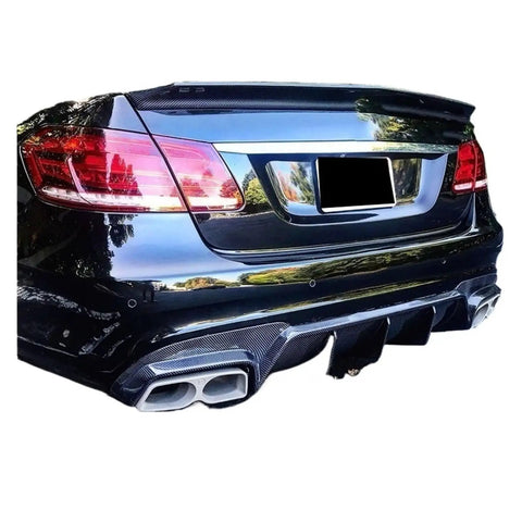Rear view of Mercedes W212 E63 E63S with carbon fiber diffuser lip kit and exhaust tips for aggressive street look.