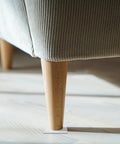 Close-up of sofa leg on Eight Pack Non Slip Silicone Furniture Feet Pads For Chair Legs And Home Furniture, transparent cushion visible.