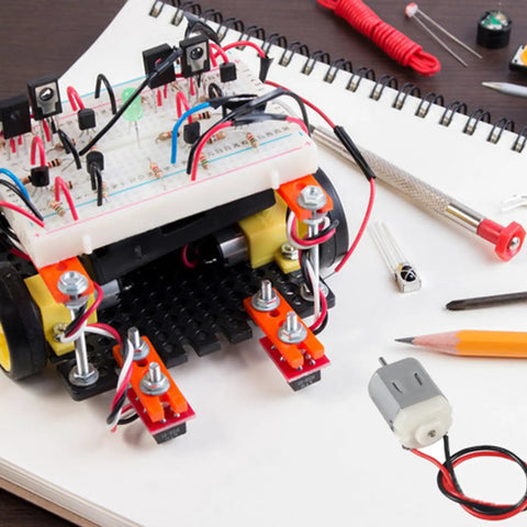 Ten Pack Of Tiny 130 Miniature DC Motors With Wire For DIY Toys And Science Projects And Small Electronics 1.5V To 6V Power Range Up To 16000 RPM At 3V Dope Micro Motors For Makers on a desk with electronics project.