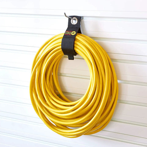 Yellow extension cord secured with Garage Organization Value Pack With Assorted Storage Straps For Cords And Hoses