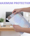 Person sealing glitter bubble mailer at home office; Glitter Bubble Mailers 30 Pack Tear Resistant Shipping Bags For Jewelry Makeup Gifts And Small Items Thick Protective Mailers For Home Office And Small Business