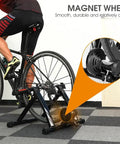 Indoor Bike Trainer With Magnetic Resistance Foldable Portable Turbo Trainer Stand in use with road bike, magnet detail.