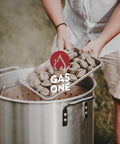 Seafood Boil Kit With Propane Burner And Regulator, 60 Quart Pot With Basket, showing clams being added to boiling pot outdoors