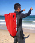 Person on beach carrying Spearfishing Float Boat With Carry Straps Foldable Flagpole And Compact Storage Red Buoy