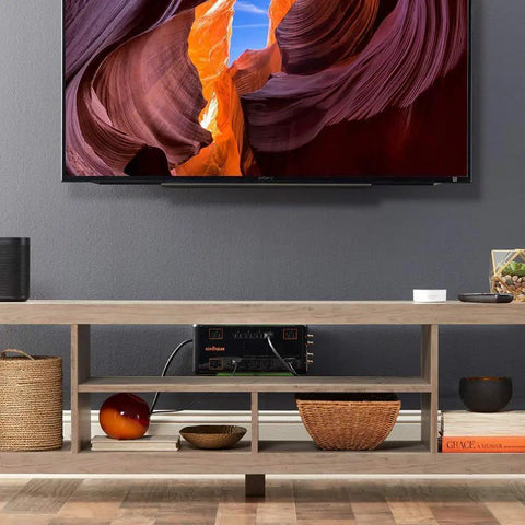 Living room setup with 12 Outlet Surge Protector Power Strip With 3420 Joules Of Surge Protection under TV in wooden stand.