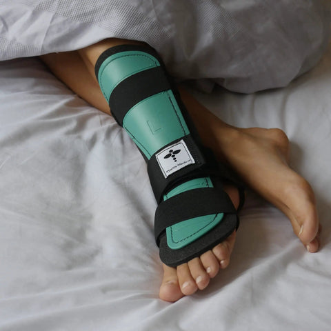 Large Left Foot Night Splint Built For Complete Achilles Rupture And Full Tendon Tear Recovery Keeps Your Foot Toes Down At One Hundred Fifty Five Degrees For Top Notch Healing And Chill Sleep Support, green and black on foot
