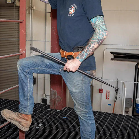 Person using Round Three Quarter Inch Thirty Inch Connecting Bar With Fifteen Degree Angled Chisel End For Easy Alignment Prying And Chiseling Made In USA Sleever Bar on metal structure