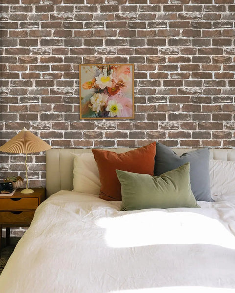 Bedroom with vintage brown brick peel and stick wallpaper, faux 3D brick for walls, eco-friendly adhesive beside bed and painting.