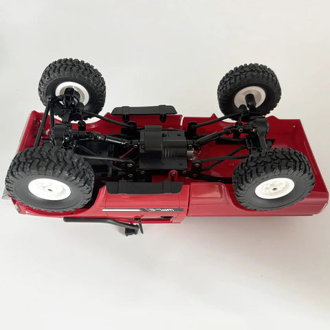 Underside view of WPL C24 RC Truck Crawler 1 16 Scale 4x4 All Terrain Off Road Pickup RTR With LED Lights showing suspension and tires.