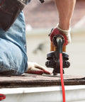 Quarter Inch 100 Ft Polyurethane Air Hose With Bend Restrictors, Flexible Workhorse For Indoor Finishing Projects, Includes One Quarter Inch Industrial Quick Coupler And Plug Kit, Red being used with a power tool on a roof