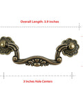 Front view of Six Pack Antique Brass Drop Bail Pulls with vintage floral base plates, 3-inch hole centers, for cabinets and dressers.