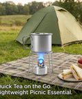 High Power Mini Alcohol Stove Spirit Burner For Camping And Backpacking in use with pot, picnic setup, and tent in background