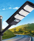 JUDYSSY Outdoor Waterproof Solar Street Light Led Wall Light, Outdoor Dusk to Dawn Solar Flood Light mounted on pole near scenic road.
